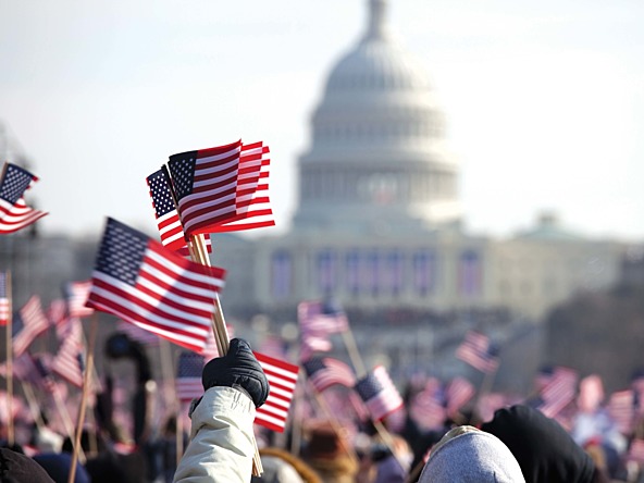 crowd waving US flags in front of White House